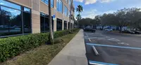Commercial office landscape with maintained hedges, clean sidewalks, and crisp edges