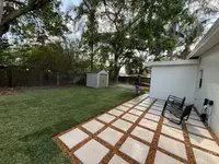 Residential backyard hardscape with stepping pads, fresh turf, and clean outdoor layout